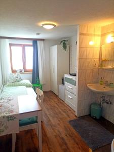 a small bedroom with a bed and a sink at Gästehaus Alpenblick in Innsbruck