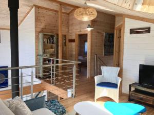 Una sala de estar con escalera en una cabaña. en Superbe maison finlandaise en bois, en Tosse