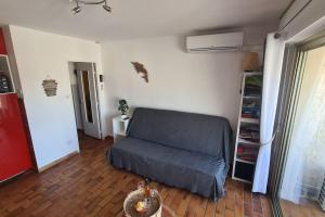 a living room with a couch and a book shelf at COSY Studio Wifi Clim Terrasse parking in Six-Fours-les-Plages