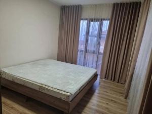 een slaapkamer met een bed voor een raam bij Royal Beach Club Hotel in Chok-Tal