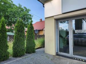 un edificio con arbustos junto a una puerta de cristal en Cozy Apartament Country 6persons close to airport en Cracovia