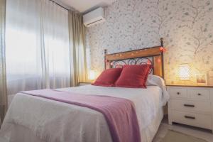 - une chambre avec un lit doté d'oreillers rouges dans l'établissement The new Gurami Beach House, à Rincón de la Victoria