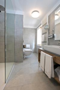 uma casa de banho com uma banheira, um lavatório e um WC. em Olimpia Hotel em Bormio