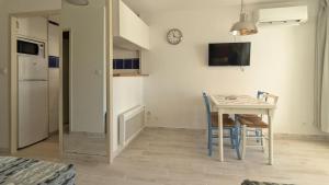 a kitchen and dining room with a table and chairs at Residence Ulysse Port Camargue in Le Grau-du-Roi
