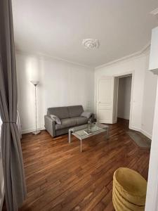 a living room with a couch and a table at Charmant Appartement Parisien in Paris