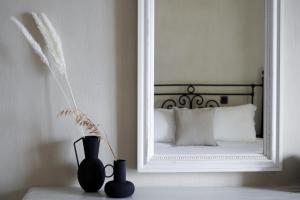 uno specchio e due vasi su un tavolo in una stanza di Agapitos Villas & Guesthouses ad Agios Ioannis Pelio