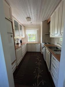 a small kitchen with white cabinets and a window at Kaliininkuja in Lapua