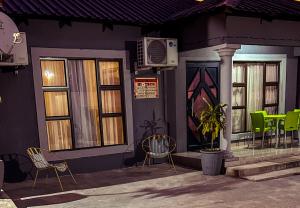 a building with chairs and tables and windows at Mjejane Debs guest house in Hectorspruit
