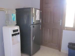 una cocina con nevera de acero inoxidable junto a una puerta en Apartment Du-2 Candolim, en Candolim