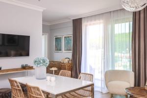una sala da pranzo con tavolo e sedie bianchi di Baltic Riviera Concept Apartament z widokiem na morze i las a Międzyzdroje