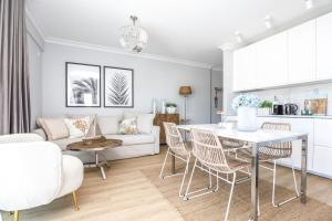 un soggiorno con tavolo, sedie e divano di Baltic Riviera Concept Apartament z widokiem na morze i las a Międzyzdroje