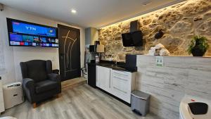 a waiting room with a chair and a flat screen tv at Loft con Jacuzzi os Arcos in Sober