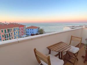 einen Balkon mit einem Tisch, Stühlen und Meerblick in der Unterkunft Re del MARE - [Lounge con vista da SOGNO] in Porto Recanati