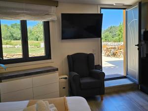 a room with a chair and a tv and a bedroom at Loft con Jacuzzi os Arcos in Sober