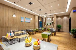 a restaurant with wooden walls and tables and chairs at Morning Hotel, Changsha Huanghua International Airport in Gutang