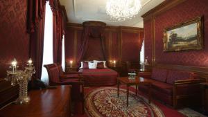 a bedroom with a bed and a couch and a chandelier at Hotel Koronny in Zamość