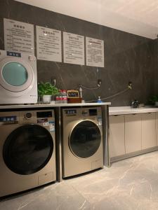 eine Küche mit 2 Waschmaschinen und einer Mikrowelle in der Unterkunft Morning Hotel, Changsha Huanghua International Airport in Gutang