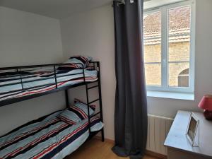 - une chambre avec 2 lits superposés et une fenêtre dans l'établissement Appartement meublé Duplex T3., à Baume-les-Dames