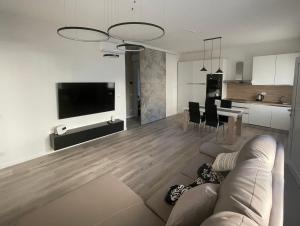 a living room and kitchen with a couch and a television at GIGI HOUSE [appartamento PIAZZA MAZZINI] 300m dal mare in Lido di Jesolo