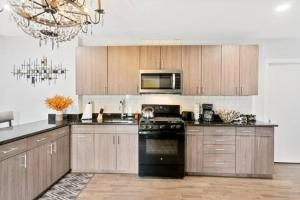 a kitchen with wooden cabinets and a black stove top oven at Upscale Luxury Suites Minutes From Center City in Philadelphia