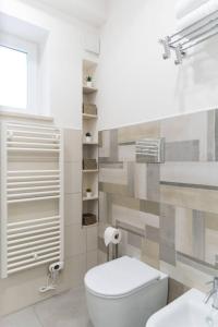 uma casa de banho branca com um WC e um lavatório em Lovely Modern Apartment em Modica