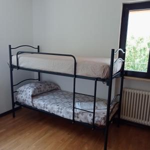 two bunk beds in a room with a window at Villetta maison hélène CIR n 0391 in Aosta