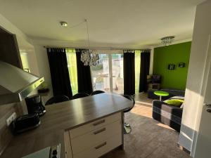 eine Küche und ein Wohnzimmer mit grünen Wänden und einem Sofa in der Unterkunft Ferienwohnung KWi 73 EG "grüne Oase" in Graal-Müritz