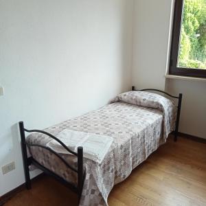 a small bed in a room with a window at Villetta maison hélène CIR n 0391 in Aosta +28 photos