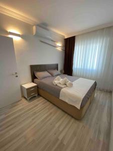 een slaapkamer met een groot bed met witte lakens bij Apart Daire in Didim
