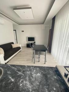 een woonkamer met een bank en een tafel bij Apart Daire in Didim