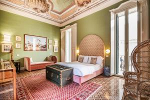 a bedroom with a bed and a chair and a table at Palazzo Flora in Gallipoli
