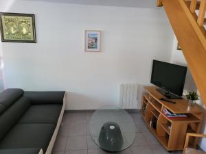 - un salon avec un canapé et une télévision dans l'établissement Appartement meublé Duplex T3., à Baume-les-Dames