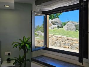 a window in a room with a stone wall at Loft con Jacuzzi os Arcos in Sober