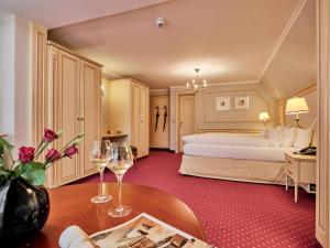 Habitación de hotel con cama y mesa con copas de vino en Hotel Reppert, en Hinterzarten