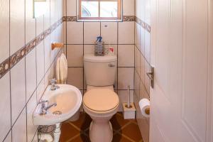 a small bathroom with a toilet and a sink at Kwetu Guest Farm in Swellendam