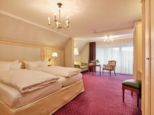 ein Hotelzimmer mit zwei Betten und einem Schreibtisch in der Unterkunft Hotel Reppert in Hinterzarten