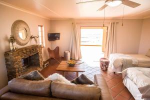 a living room with a couch and a fireplace at Kwetu Guest Farm in Swellendam