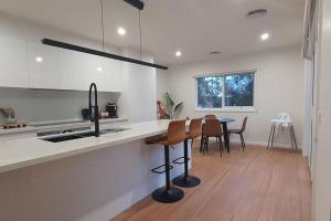 a kitchen with a sink and a table with chairs at Ballarat Holiday Homes - Hopetoun Cottage - Minutes from Ballarat CBD - Sleeps 1 to 6 in Ballarat
