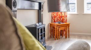 a living room with a fireplace and a tv at Coniston in Sawrey