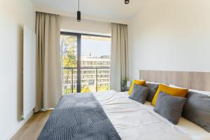 ein Schlafzimmer mit einem großen Bett und einem großen Fenster in der Unterkunft Apartament Shellter Design przy plaży- Rogowo in Rogowo