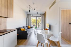 a living room with a couch and a table at Apartament Shellter Design przy plaży- Rogowo in Rogowo