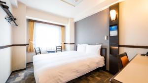 um quarto de hotel com uma cama e uma janela em Toyoko Inn Hikone eki Higashi guchi em Hikone