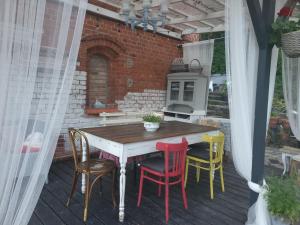 a table and chairs on a patio with a kitchen at Krzywa Apartamenty in Lidzbark Warmiński