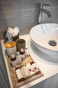 a bathroom sink with a tray with bottles of honey at Villa Danae - Lindos in Líndos