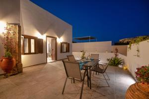 an outdoor patio with a table and chairs at Villa Danae - Lindos in Líndos