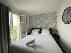 a bedroom with a large white bed with a window at Appt Vue Place de Toscane - 4min Disneyland-PARIS in Serris