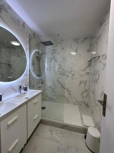 een badkamer met een douche, een wastafel en een bad bij Appt Vue Place de Toscane - 4min Disneyland-PARIS in Serris