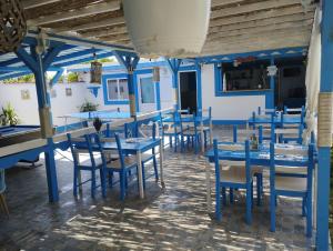 una sala da pranzo con tavoli e sedie blu di Pensiune Blue Coral Jurilovca a Jurilovca