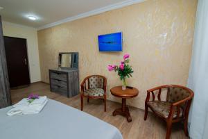 a room with a bed and two chairs and a table with flowers at LEA in Margahovit