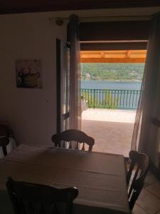 - une table et des chaises dans une chambre avec fenêtre dans l'établissement Direkt na moru - Bungalov, à Šibenik